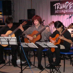 3 Guitar Students Playing On Stage At Trumpets Jazz Club And Restaurant
