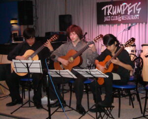 3 Guitar Students Playing On Stage At Trumpets Jazz Club And Restaurant