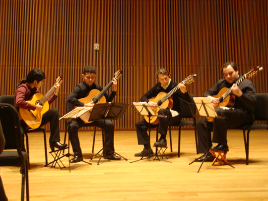 4 guitarists playing on stage